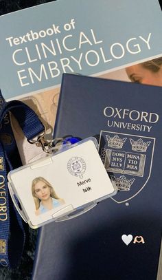 a passport, id card and keychain sitting on top of a pile of books