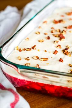 a casserole dish filled with white frosting and nuts