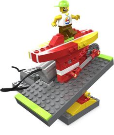 a lego man riding on top of a red and yellow boat with a green helmet