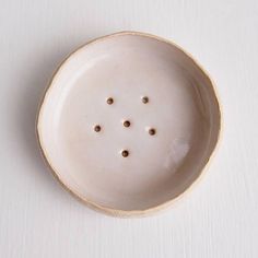 a white ceramic bowl with holes in it