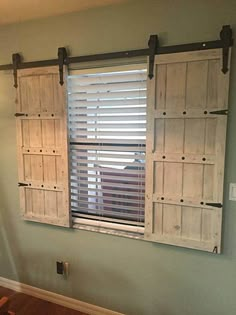 an empty room with wooden shutters on the windows