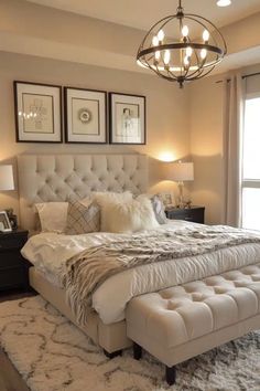 a bedroom with a bed, chandelier and pictures on the wall