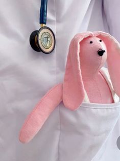 a pink stuffed animal is in the pocket of a doctor's white lab coat