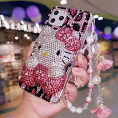 a person holding up a hello kitty phone case