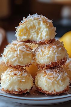 a stack of coconut macaroni and cheese bites on a plate with lemons in the background