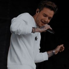 a man with tattoos on his arm holding a microphone