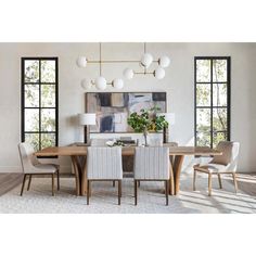 a dining room table and chairs in front of large windows