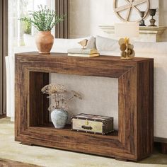 a living room with a couch, table and vase on the end shelf in front of it