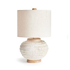 a white ceramic table lamp with a beige shade on it's base and a light wood base