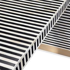 a black and white striped bed with gold trimmings on the bottom half of it