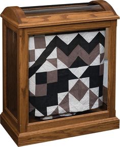 a wooden box with a black and white quilt in it