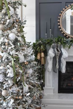 a decorated christmas tree with stockings hanging from it's sides in front of a fireplace