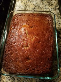 a square cake in a glass dish on a counter