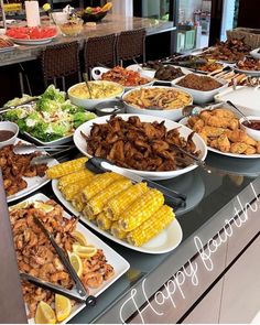 a buffet filled with lots of different types of food on top of plates and bowls