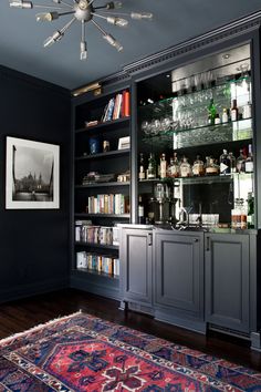 a room that has a rug and some shelves with liquor bottles on top of it