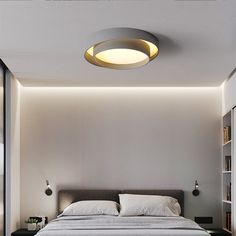 a bedroom with a bed, bookshelf and lights on the wall above it