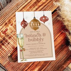 a wine glass sitting on top of a wooden table next to a card that says brunch and bubbly