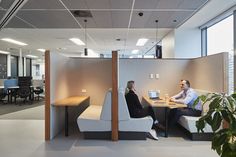 two people sitting at a table in an office setting