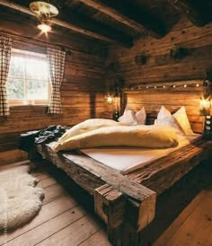 a large bed sitting inside of a wooden room next to a window with lights on it