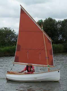 a person on a small sailboat in the water