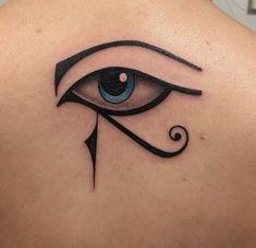 an eye tattoo on the back of a woman's shoulder