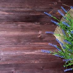 some blue flowers are sitting on a wooden table next to burlock and twine