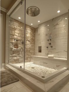 a bathroom with a walk in shower next to a white bathtub and stone wall