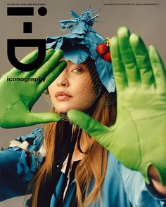 a woman wearing green gloves and holding her hands up in front of her face with the letter f on it