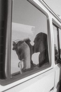 two stuffed animals are sitting in the window of a car and one is sticking its head out