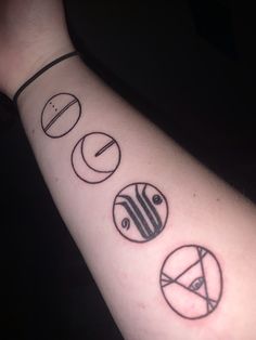 a person with a tattoo on their arm that has five different symbols in the shape of circles