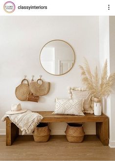 a wooden bench sitting under a mirror next to two baskets on top of a table