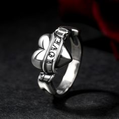 a silver ring with the word love written on it and a heart in the middle