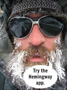 a man with snow on his face wearing sunglasses and a knitted hat is looking at the camera