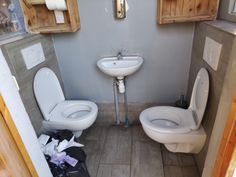 a bathroom with two toilets and a sink