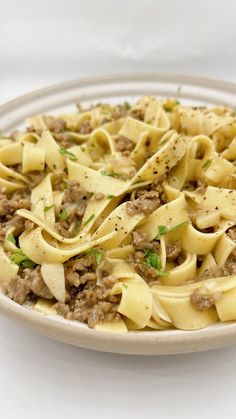 a white plate topped with pasta and meat