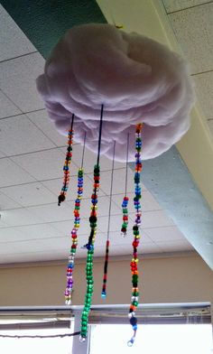 a cloud with beads hanging from it's side in front of a windowsill