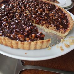 a chocolate pie on a plate with one slice missing