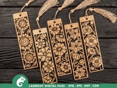 four wooden tags with flowers and tassels hanging from them on a wood background