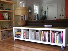 a living room filled with furniture and a large book shelf next to a couch on top of a hard wood floor