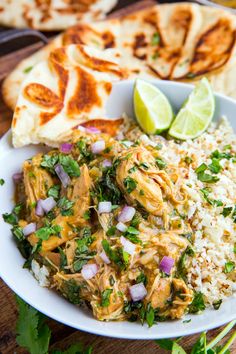 a white plate topped with rice and chicken next to quesadillas