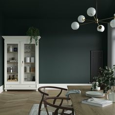 a dining room with dark green walls and white furniture