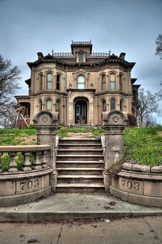 an old house with stairs leading up to it