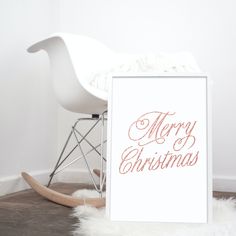 a white rocking chair sitting next to a christmas card on top of a wooden floor