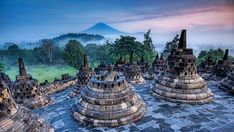 many stone structures are in the foreground with a mountain in the backgroud