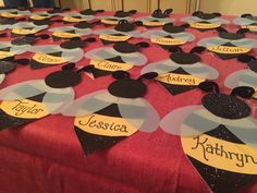 a table topped with lots of mickey mouse ears and name tags on top of it