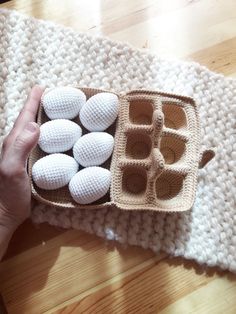 a person holding an egg carton filled with white eggs