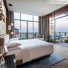 a bedroom with large windows overlooking the ocean