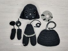 crocheted items are displayed on a white surface, including a black hat and gloves