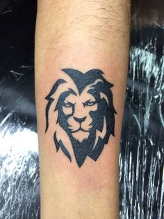 a lion head tattoo on the left forearm and leg, with black ink in it