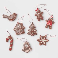 christmas ornaments are hanging from strings on a white surface with snowflakes and candy canes